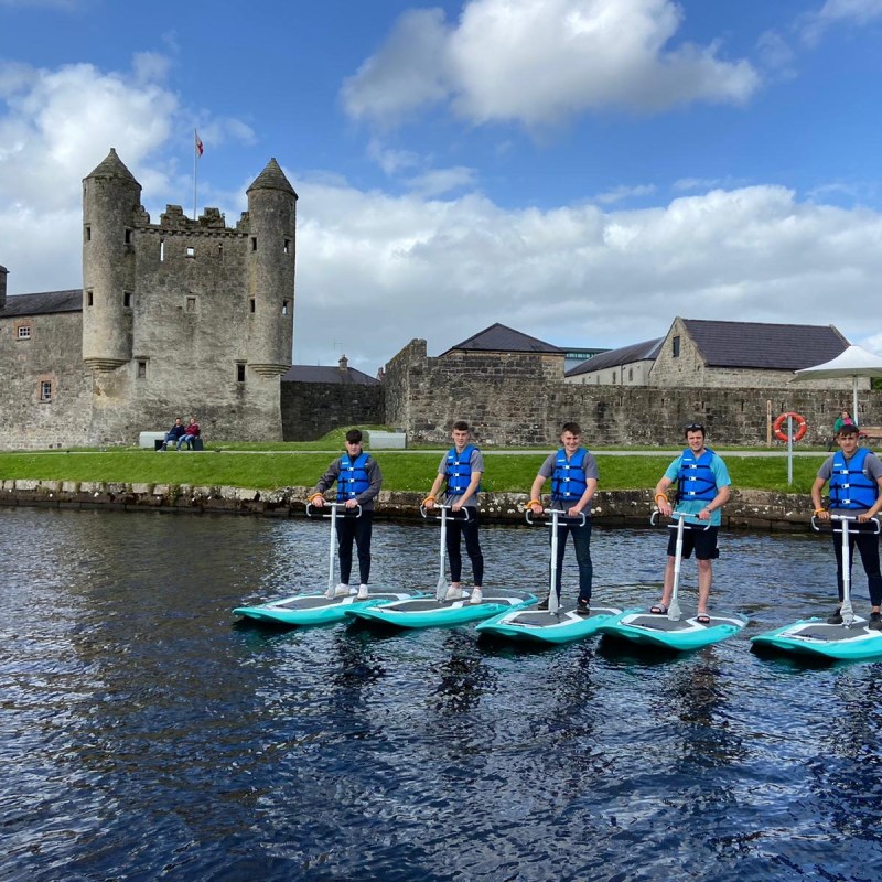 a group of people standing next to a body of water