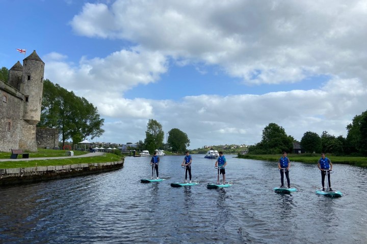 a group of people standing next to a body of water