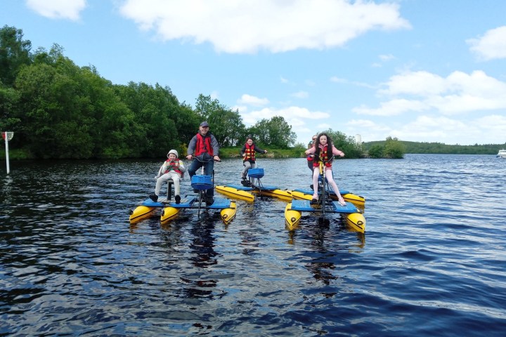 a group of people riding on the back of a boat in the water